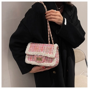 Detail of pink tweed shoulder bag with white pearl trim and golden chain strap