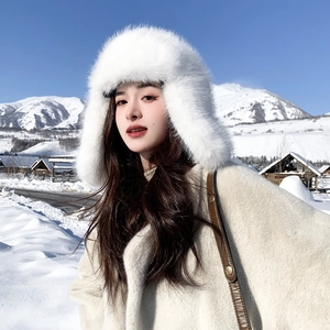 Plush white faux fur winter trapper hat with ear flaps shown in snowy outdoor setting