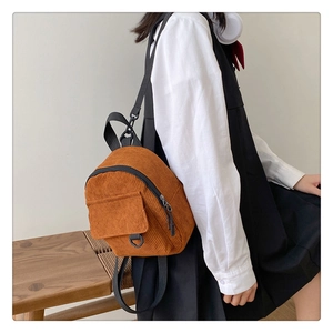 Detail of vintage corduroy mini backpack showing textured fabric and front pocket flap