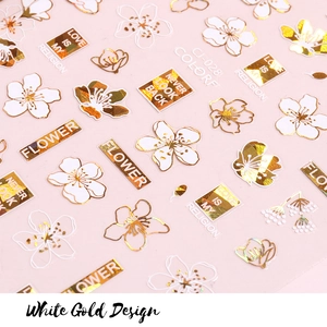 Detail view of white gold nail stickers with daisy motifs and gold foil lettering