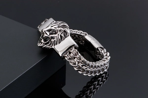 Detailed macro view of vintage lion head relief on a woven stainless steel men's bracelet