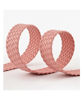Close-up of pink woven leather belt featuring intricate braided texture and round buckle