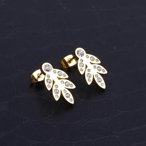 Elegant gold leaf shape stud earrings with crystals on textured black leather background