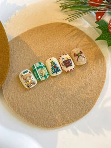 Detail of Christmas press-on nails featuring 3D embossed bears and gingerbread man