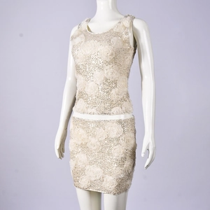 Detail of cream sequin two-piece set with 3D floral accents and hollowed design
