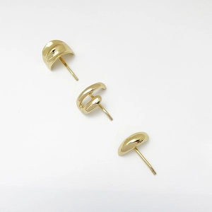 Close-up of minimalist gold geometric earring set including C-shape and teardrop designs