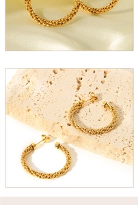 Detailed view of 18K gold plated C-shaped twisted hoop earrings on textured stone base