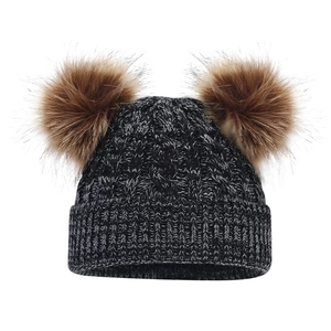 Detailed knit texture of children's winter pompom hat with thick cable stitching
