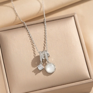 Elegant silver necklace with moonstone and cubic zirconia pendant on a jewelry box