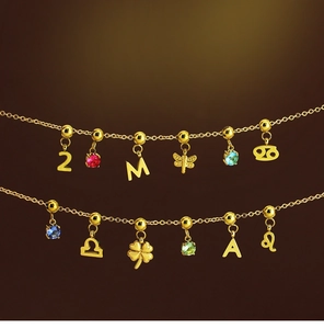 Detailed view of two 18K gold zodiac charm bracelets with colorful crystal pendants
