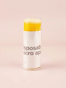 Detailed macro view of yellow disposable micro applicators in a clear storage tube