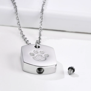 Detailed view of silver urn pendant necklace with paw print and unscrewed sealing bolt