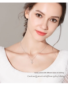 Detailed close-up of a Moissanite cross pendant necklace worn by a female model on the neck
