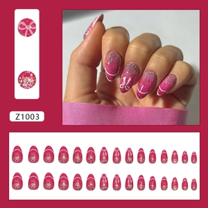 Sparkly pink almond press-on nails set with glitter, white lines and bow decorations