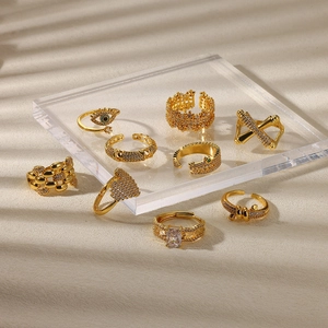 Elegant set of 8 gold minimalist rings with zirconia and evil eye designs on acrylic