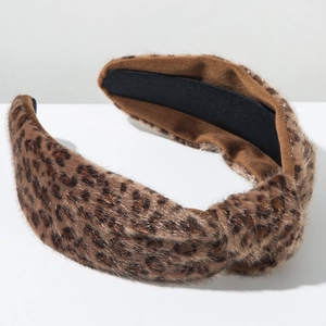 Détail d'un serre-tête en peluche léopard avec design à nœud croisé et texture douce