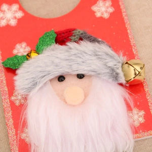 Detail of Christmas door hanger with red and white fabric, plush fur and gold bells