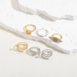 Detailed close-up of a diverse stack of gold and silver plated gemstone open rings