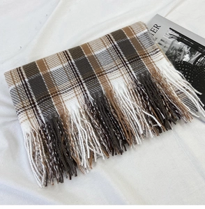 Close-up of brown and beige plaid scarf with fringe detail on a white fabric background