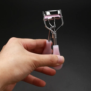 Pink and silver eyelash curler with comb and ergonomic handle for natural lash lift