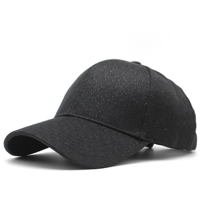 Detail showing black baseball cap with shimmering sequins and premium woven texture