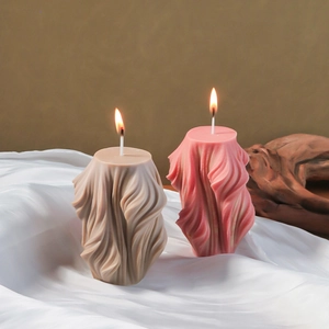 Artistic geometric spiral pillar candle mold with elegant draped fabric texture design