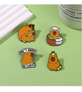 Lot de quatre pin's émaillés capybara mignons sur fond vert clair avec diverses poses