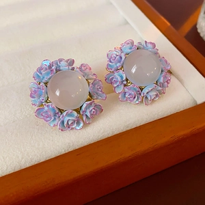Macro shot of silver flower stud earrings with lavender gems in a luxury display box