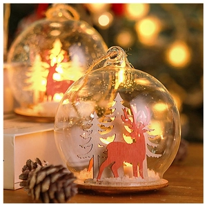 Detail of Christmas glass globe with red wooden reindeer, snowy tree and rustic hemp rope