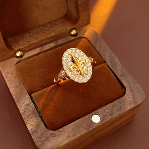 Vue détaillée d'une bague fleur de lys dorée vintage avec cristaux en boîte bois