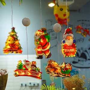 Detail of warm white LED Christmas suction cup lights showing Santa and tree on a window