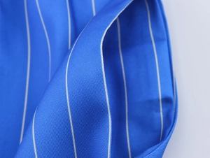 Gros plan détaillé du pyjama à rayures bleues et blanches montrant la texture du tissu