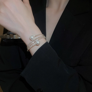Detail of multi-layer silver bangle with faux pearls and sparkling rhinestones