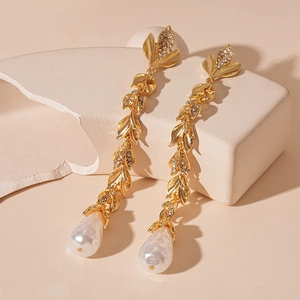 Elegant gold vine earrings with leaf crystals, long tassels, and white teardrop pearls