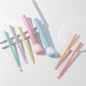 7-piece macaron-colored makeup brush set with synthetic bristles on white pedestals