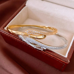 Macro detail of gold and silver snake bracelets with cubic zirconia pavé in a gift box