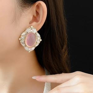 Detailed view of vintage gold earring featuring pink oval stone and enamel work