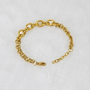 Detail of a gold double-layer chain bracelet on white plush background for fashion styling