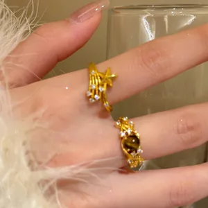 Makroaufnahme von 18K vergoldeten Vintage-Ringen mit Zirkoniasteinen und braunem Edelstein