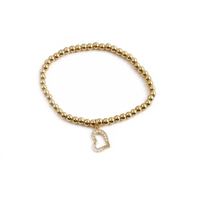 Detail view of a gold beaded elastic bracelet featuring a sparkling heart-shaped zircon charm