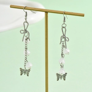Long vintage silver butterfly earrings with white pearls and bow detail on T-stand