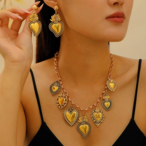 Nahaufnahme eines Models mit goldener Barock-Herz-Halskette und passenden Ohrringen