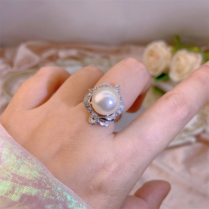 Detail of elegant oversized pearl ring with crystal pavé on a silver-toned wavy band