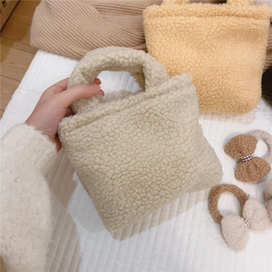 Gros plan détaillé du mini sac à main blanc crème en fausse fourrure pelucheuse