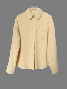 Detalle de la tela de lino amarillo claro con bolsillo frontal en camisa de manga larga