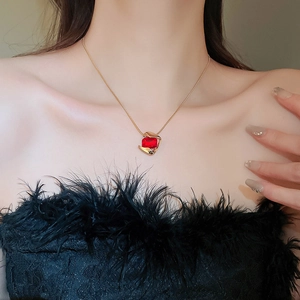 Detail of red square pendant necklace with gold frame on model neck