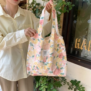 Dettaglio della borsa shopper in tela floreale con etichetta LOVE e HIDDEN FLOWER all'aperto