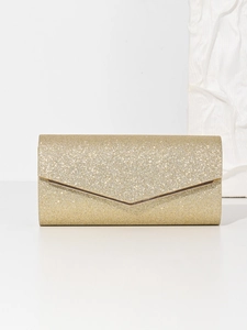 Detail of glitter fabric texture and V-shaped metal trim on gold evening clutch bag