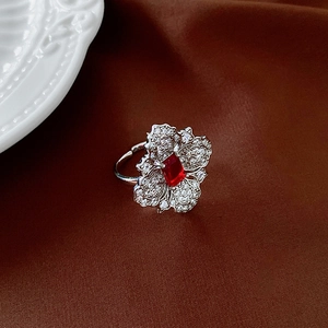 Detailed macro view of a silver flower ring featuring a red rectangular gemstone inlay