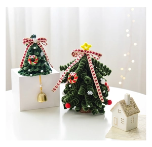 Close-up of handmade velvet Christmas tree with red bows and tiny bells for desk decor